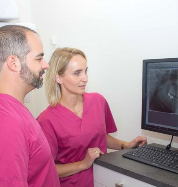 Sebastian Koller und Angestellte betrachten Patientenaufnahmen auf einem Computer