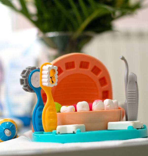 Spielerische Darstellung von Zähnen und Kiefer mit Zahnbürsten für Kinder