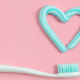 Zähneputzen mit Zahnbürste und Zahnpasta in Herzform