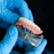 Künstliche untere Zahnreiche wird von zwei Händen in Latexhandschuhen gehalten